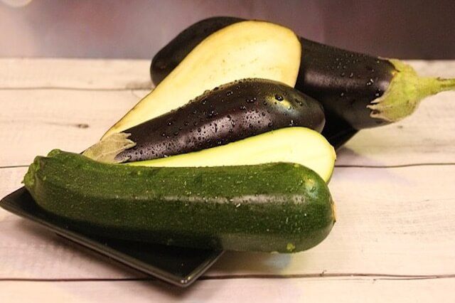 aubergine-courgette-recette-curry-legumes Aubergines et courgettes sur une assiette noire