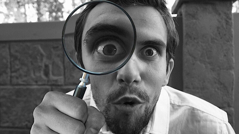 Homme avec une grosse loupe grossissante